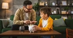Un père montre à son fils comment économiser de l’argent à la tirelire à la maison