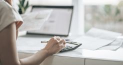 Focus on a woman's hand hitting a calculator