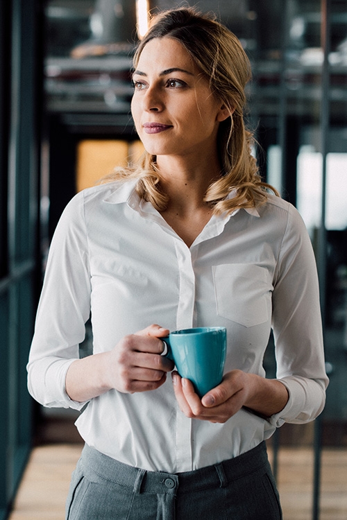 Femme d'affaire avec une tasse de caf&eacute; dans les mains